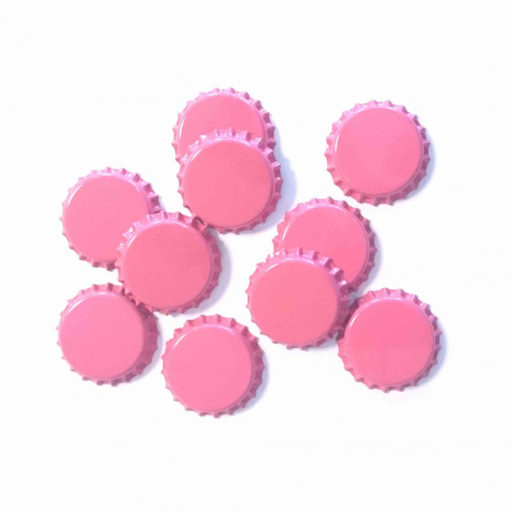 Ti Brewolution Korker 26 mm rosa flaskekorker (fra en pakke med 100 stk.) er spredt på en hvit bakgrunn.
