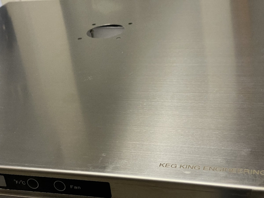 Et nærbilde av Keg King Topplate av rustfritt stål til Kegerator Series 4 og XL viser en sirkulær utskjæring, KEG KING-merket i hjørnet og delvis synlige kontrollknapper merket F/°C og Fan.