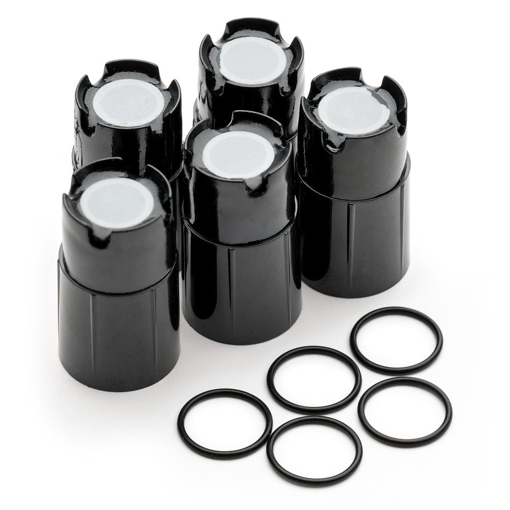 Fem Milwaukee MA841 reservemembraner for oppløst oksygensonder, i svart plast med hvite topper, er plassert sammen med fem svarte O-ringer i gummi foran, alt vist på en hvit bakgrunn.