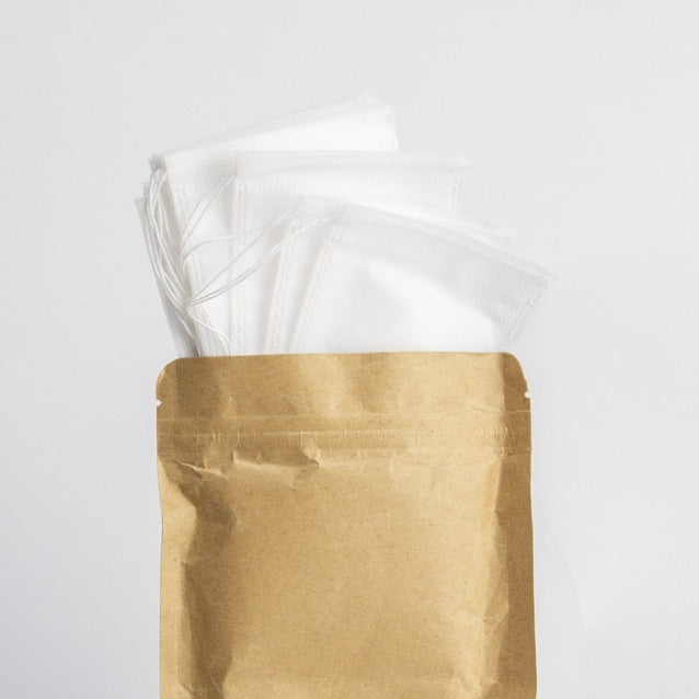 En brun papirpose merket "uKeg Nitro Bryggeposer 10 stk" fra GrowlerWerks er åpen, med flere brettede hvite filterposer på innsiden - perfekt for å holde uKeg Nitro-tilbehøret rent og beskyttet.