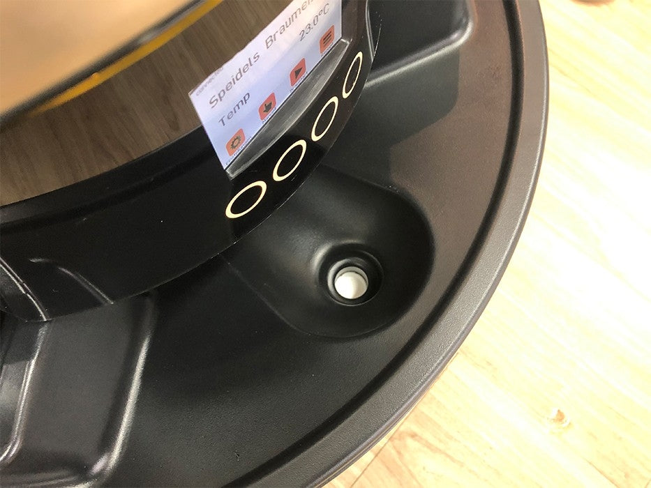 Nærbilde av Speidel Base med hjul til Braumeister 50L, som viser det digitale kontrollpanelet med runde berøringsknapper på et svart apparat, plassert på en treflate.