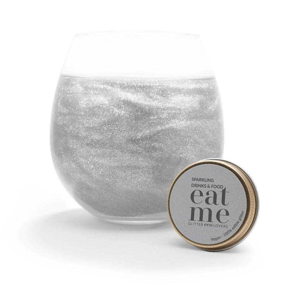 Et glass med en glitrende drink står ved siden av Eco Lovers' Eat Me Glitter Clear 20 ml - perfekt spiselig glitter til å dekorere kaker med eller til å gi mat og drikke et ekstra skimmer.