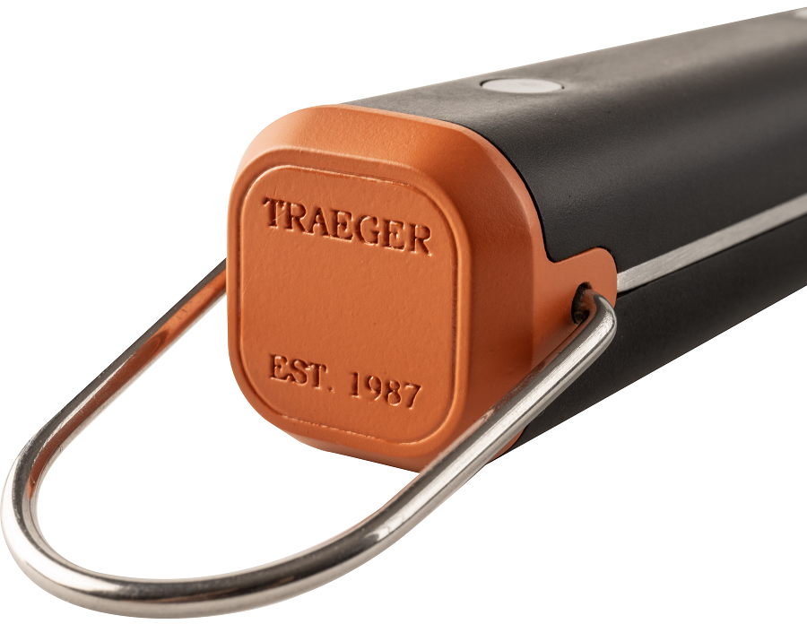 Nærbilde av Traeger BBQ Spatel fra Traeger, med oransje hette, svart kropp, rustfritt stål metallhåndtak og "TRAEGER EST. 1987" preget på endepartiet av premium grillutstyr.
