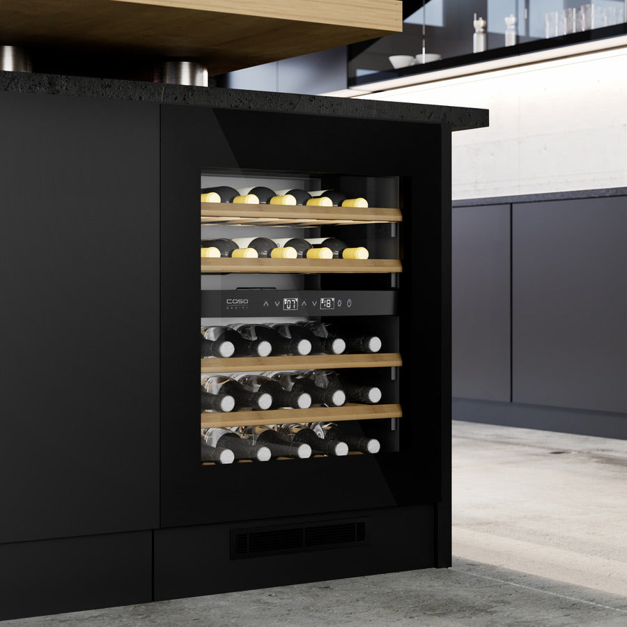 Opplev sofistikert vinlagring med Caso WineDeluxe WDU 36, et innebygd vinkjøleskap med glassdør og elegante trehyller. Dette stilfulle, innebygde vinkjøleskapet er perfekt integrert i en moderne, svart kjøkkenøy og fylt med vinflasker, og har to temperatursoner som sikrer at vinene dine oppbevares under optimale forhold.