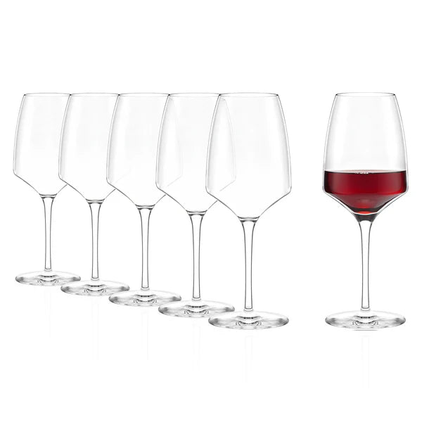 Seks Stölzle Lausits Experience rødvinsglass (450 ml, sett med 6 stk.) er plassert på rekke og rad, der bare det siste glasset til høyre er fylt med rødvin, mens resten er tomme.