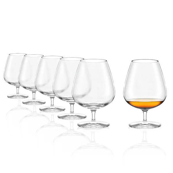 Seks Stölzle Lausitz Grandezza Cognac-glass (610 ml, sett med 6 stk.) står på rekke og rad; fem er tomme, ett har en skvett med ravfarget væske.