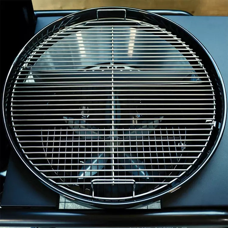 En ren, tom, rund grillrist i metall med en midtdeler sitter på SNS Master Kettle Grill 57cm - Kulegrill, og fremhever Slow 'N Sear-systemets allsidighet for perfekt grillmat.