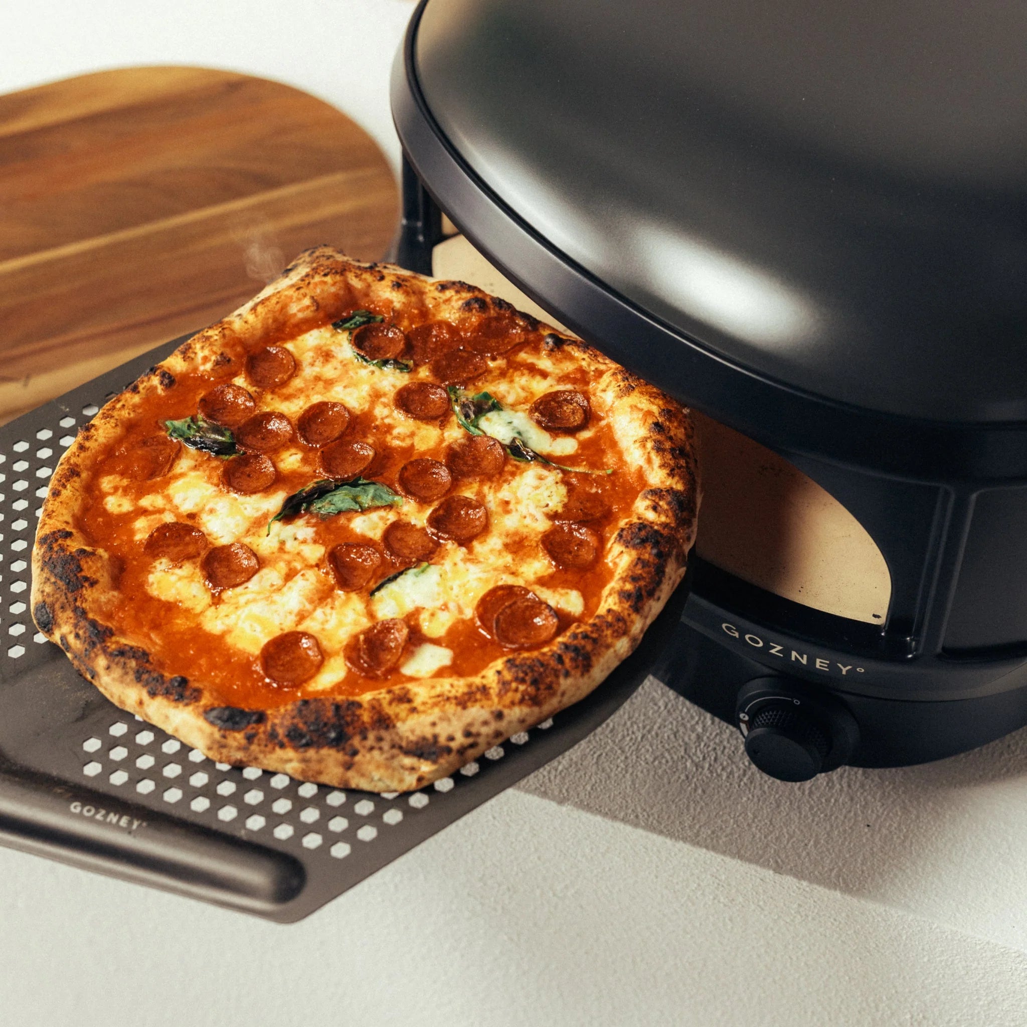 En pepperonipizza tas ut av Gozney Arc Lite, Sort - Pizzaovn, som med sitt klassiske svarte design er den perfekte kompakte pizzaovnen for hjemmelagde kreasjoner.