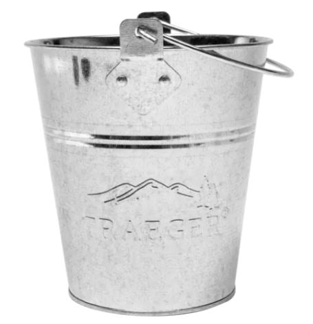 Traeger Grease Bucket fra Traeger er en kompakt, sølvfarget bøtte i galvanisert stål med håndtak og preget logo på hvit bakgrunn.
