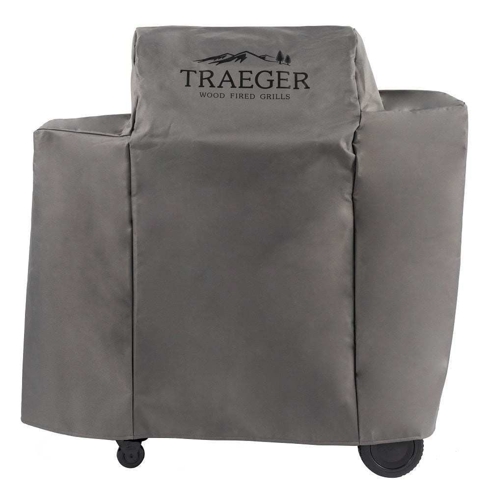 En grå Traeger Ironwood 650 vedfyrt grill med solide hjul er beskyttet av Traeger Ironwood 650 Cover - Grilltrekk.