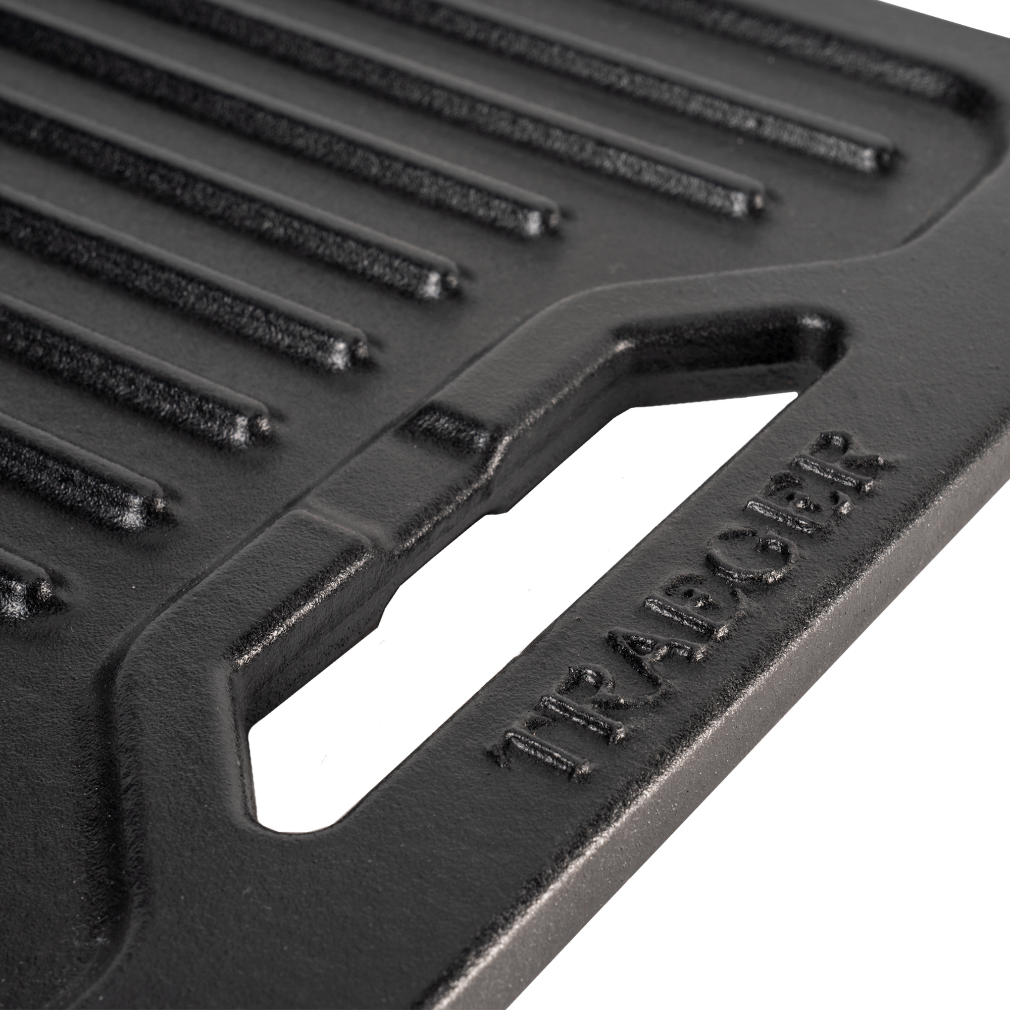 Nærbilde av en Traeger ModiFIRE Rev. Cast Iron Griddle med håndtaksspor og TRAEGER-merket - et uunnværlig Traeger-tilbehør for matlagingsentusiaster som liker å være ute.