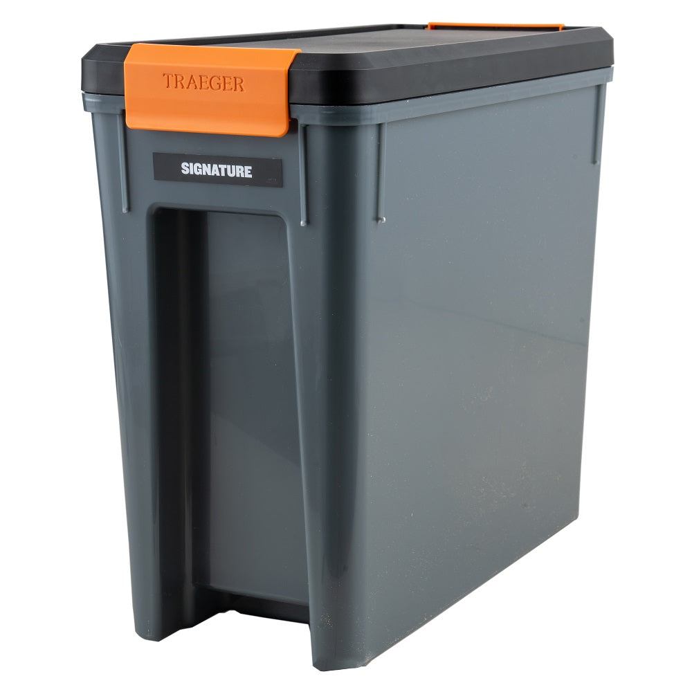 Traeger Staydry Pellet Bin and Lid fra Traeger har en grå kropp, svart lokk, oransje håndtak og synlig Signature-etikett - ideelt for oppbevaring av pellets.