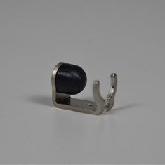 Blichmann BeerGun Clip and Seat - New Style, en liten metallbrakett med en svart gummihette i den ene enden, hviler her på en grå flate.