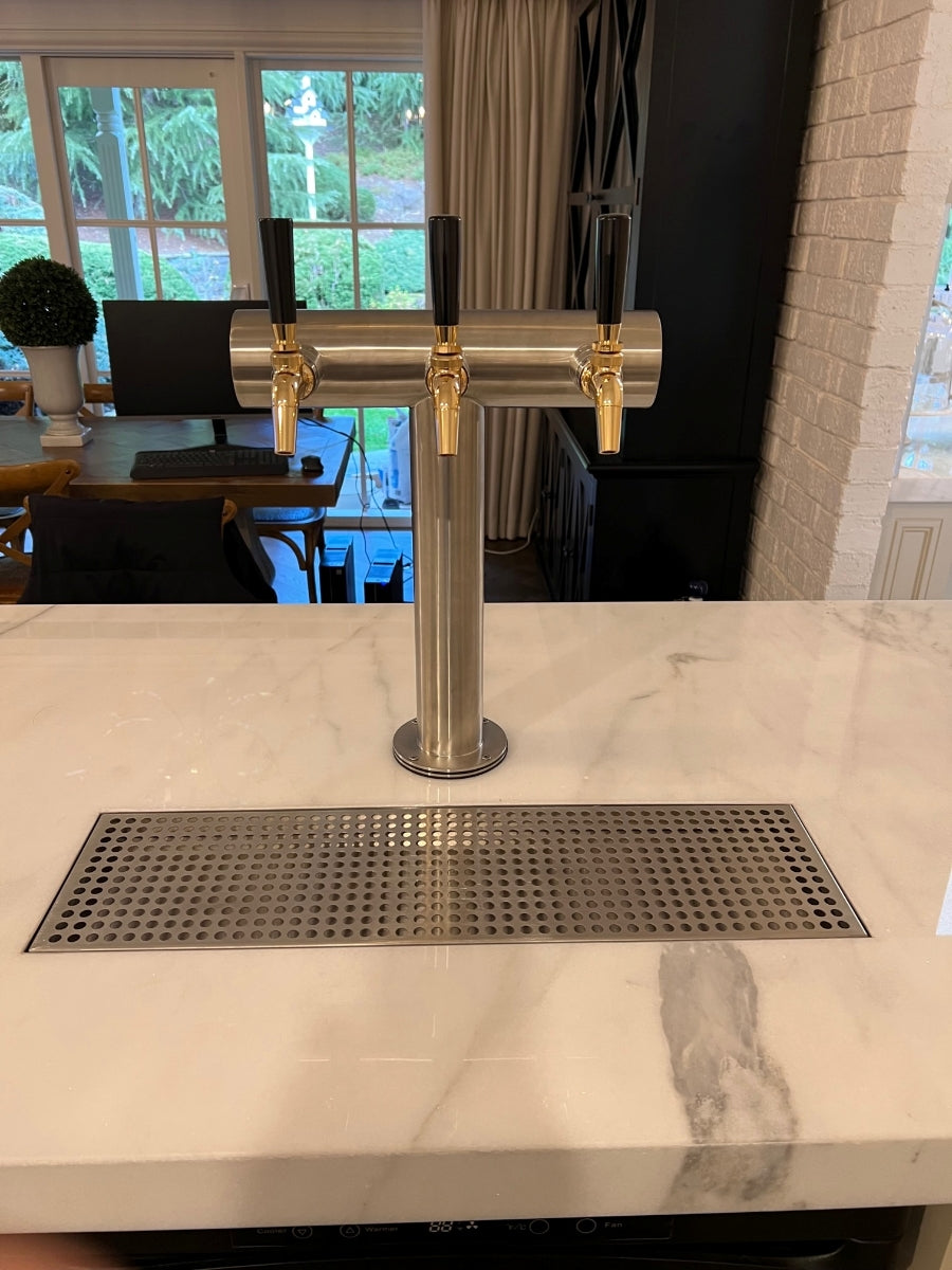 En Keg King KegMaster Telescopic Adaptor kegerator adapter for benkeplate er installert på en benkeplate i marmor med en øldispenser med tre tappesteder og dryppebrett, noe som gjør det moderne kjøkkeninnredningen enda bedre.