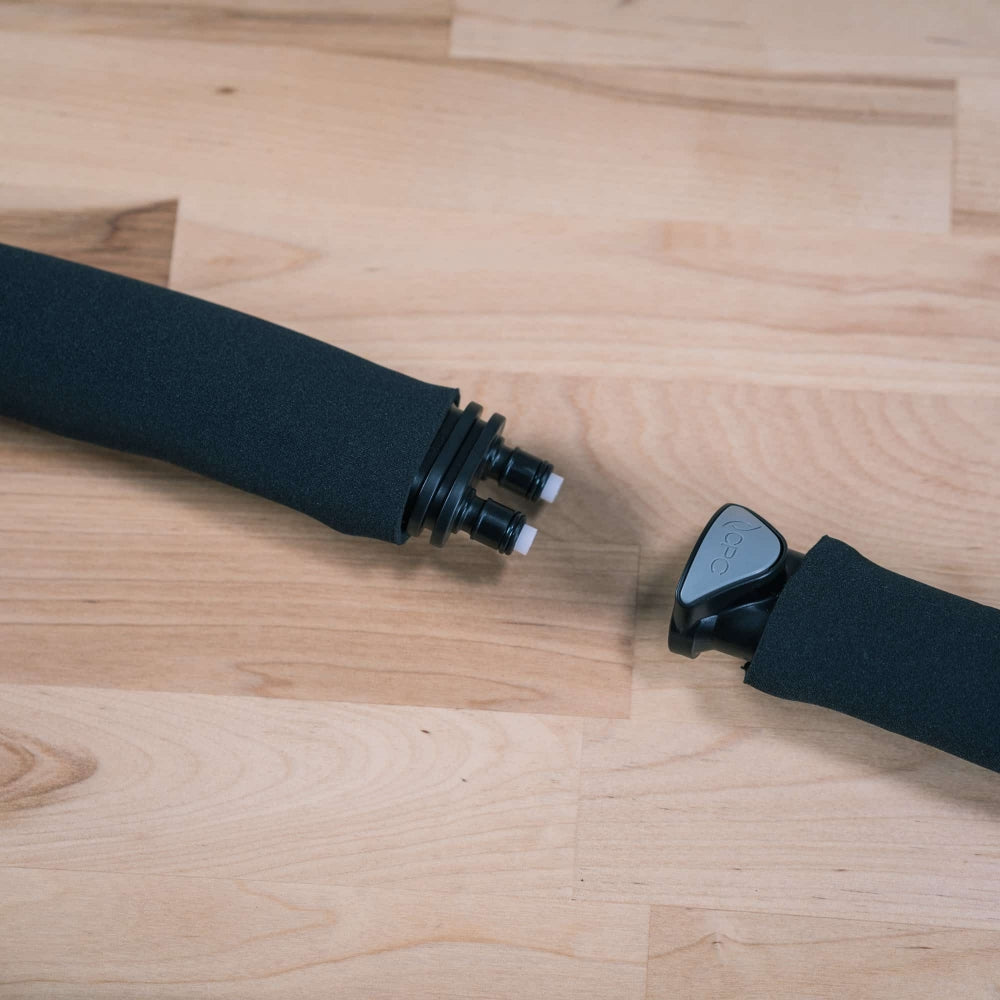 Nærbilde av to frakoblede, svarte skumhåndtak med synlige kontakter, med Ss Brewtech FTSS One Quick Disconnect Kit, som ligger på en lys treflate.