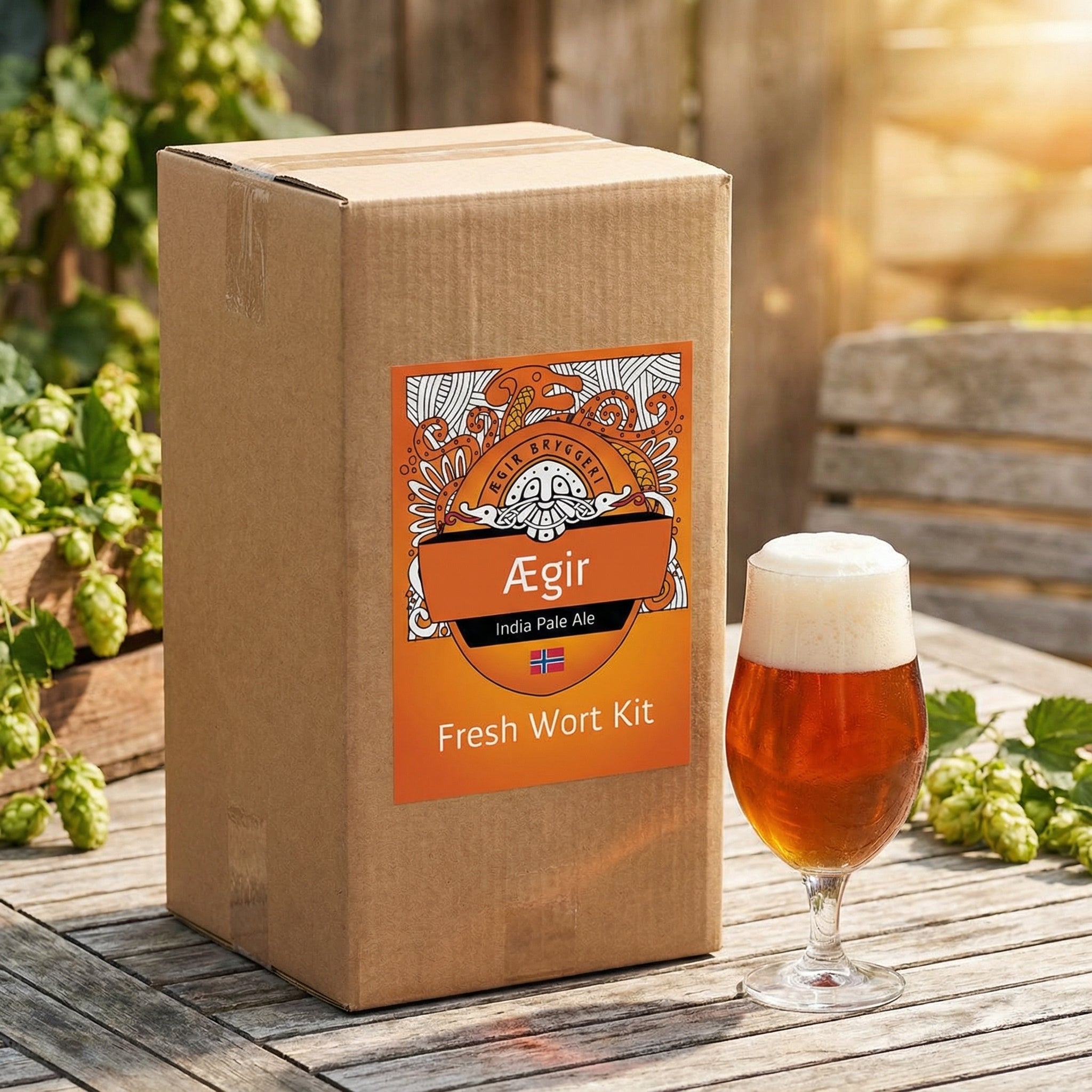En eske med Ægir IPA - 20L Fresh Wort Kit fra Ægir står på et trebord ved siden av et skummende, ravfarget øl og spredt humle, og byr på en autentisk håndverksbryggeropplevelse.