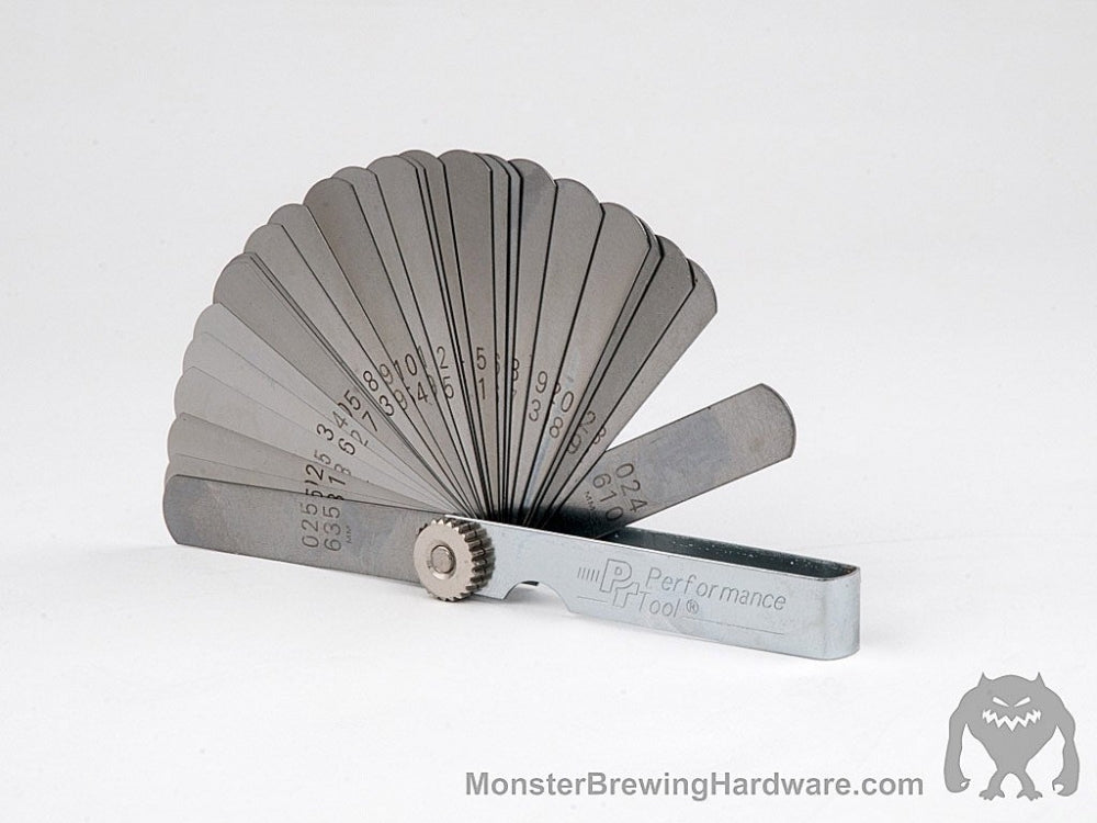 En Monster Brewing Hardware Bladføler for maltmølle med flere merkede metallblader spredt ut på en hvit bakgrunn - ideell for presise justeringer av Monster Mills-malt.