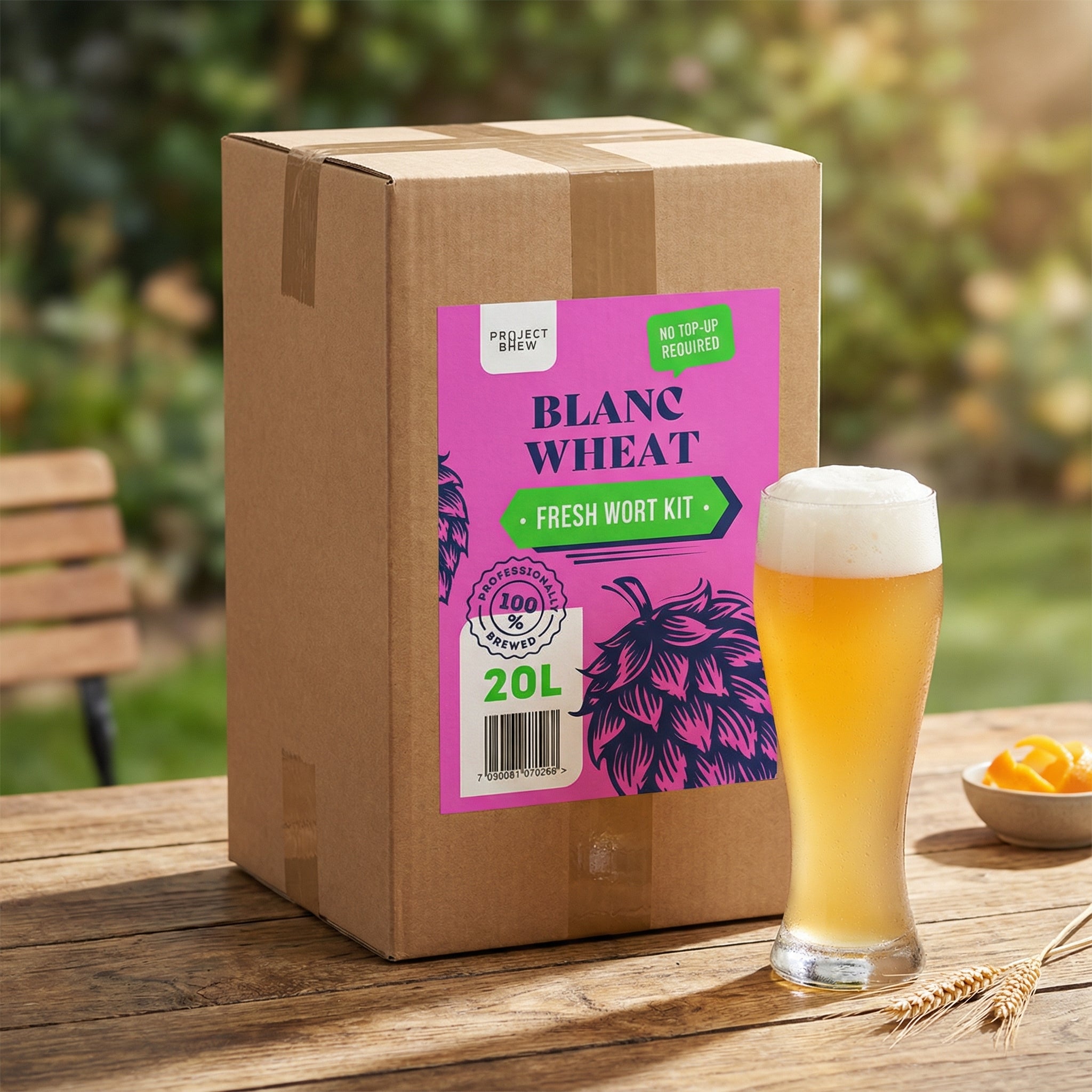 En pappeske merket Austmann Blanc Wheat - 20L Fresh Wort Kit står på et bord utendørs, ved siden av et høyt glass fransk hveteøl og et lite fat med appelsinskiver.