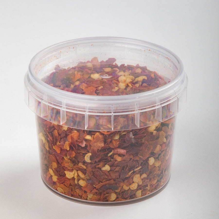 En 25 g klar plastbeholder med Enolandia Peperoncino krydderblanding, fylt med tørkede røde chiliflakes og frø, mot en vanlig hvit bakgrunn.