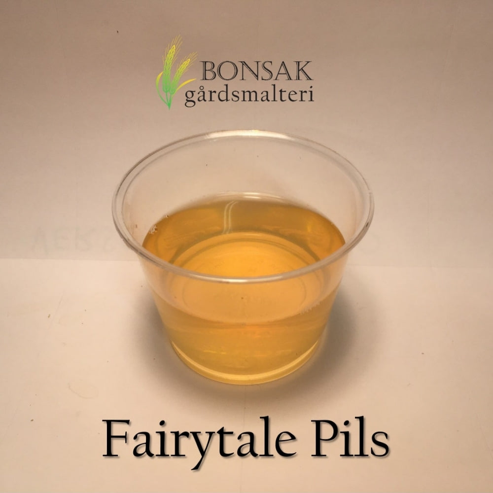 En klar kopp med lys gyllen væske ligger på en hvit overflate, merket Fairytale Pils Malt (3-4 EBC) 100G av Bonsak Gårdsmalteri, og viser deres tradisjon for førsteklasses håndverksmalt og gulvmalting.
