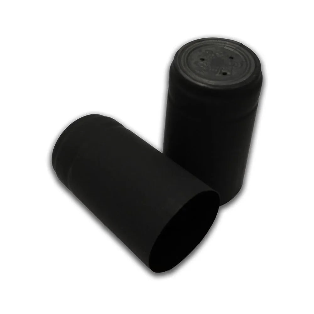 To sorte sylindriske Sorte krympehetter til vinflasker fra Handcraft Supplies - den ene stående med mønstret topp, den andre liggende på siden - begge mot en hvit bakgrunn. Pakken inneholder 30 stk.
