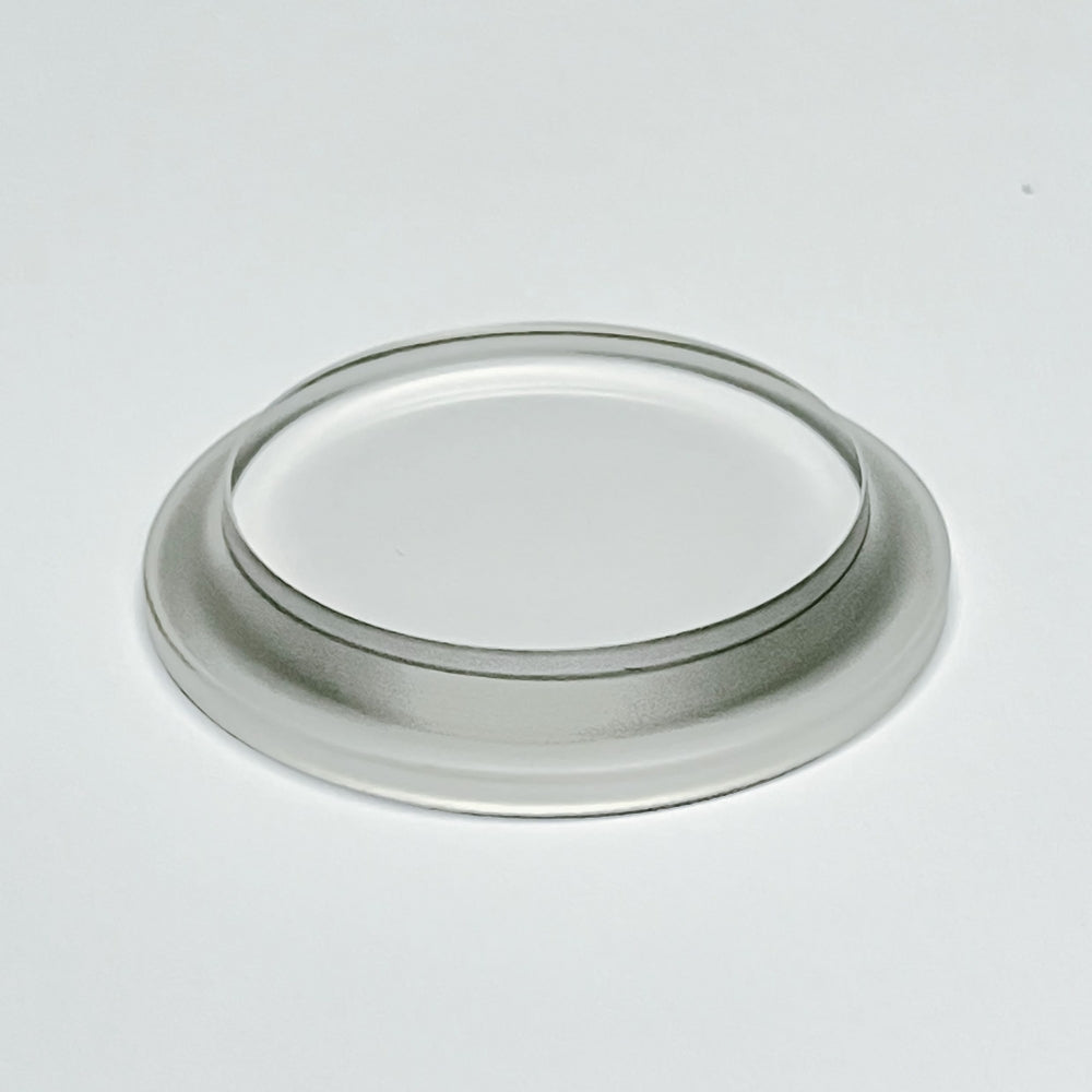 En Brewshop 1,5" Tri-Clamp Siktglass Endelokk plasseres på en flat, hvit overflate.