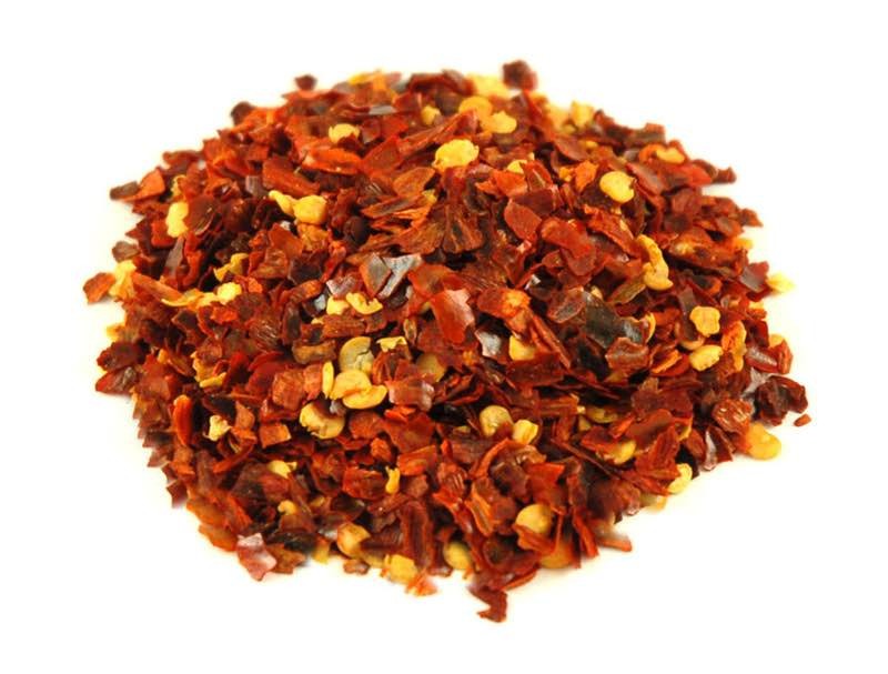 Brewshop Chili, knust 25 g: Grovknuste chiliflakes med synlige frø på en vanlig hvit bakgrunn - perfekt for å gi varme til rettene dine.