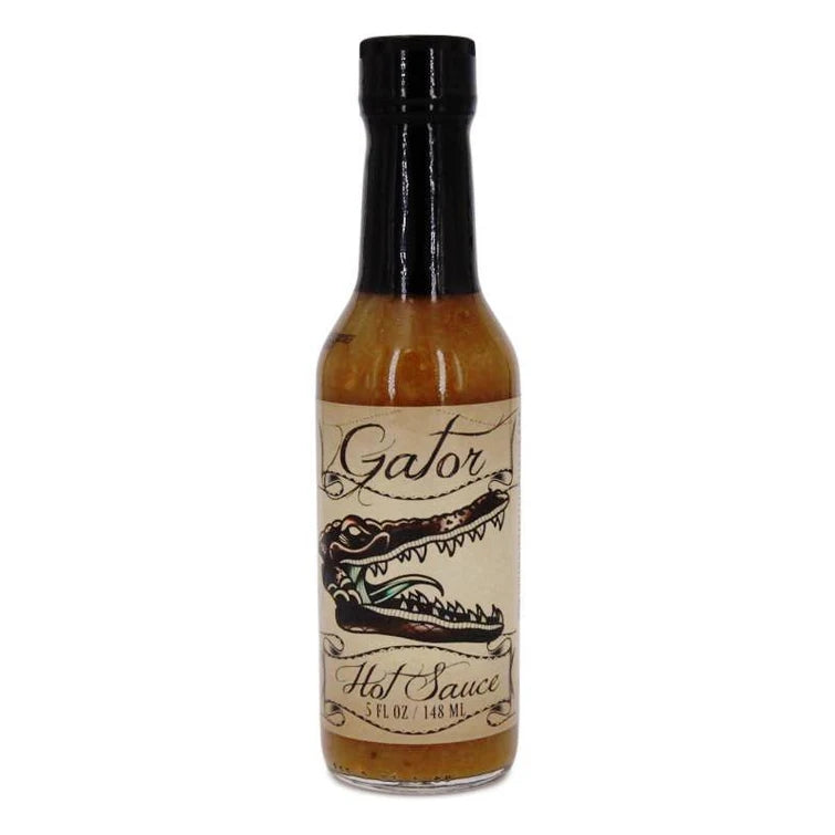 En 5 oz flaske Gator Sauce fra PuckerButt Pepper Company har et illustrert alligatorhode og leverer intens varme med Pepper X for en virkelig sterk chilipølseopplevelse.
