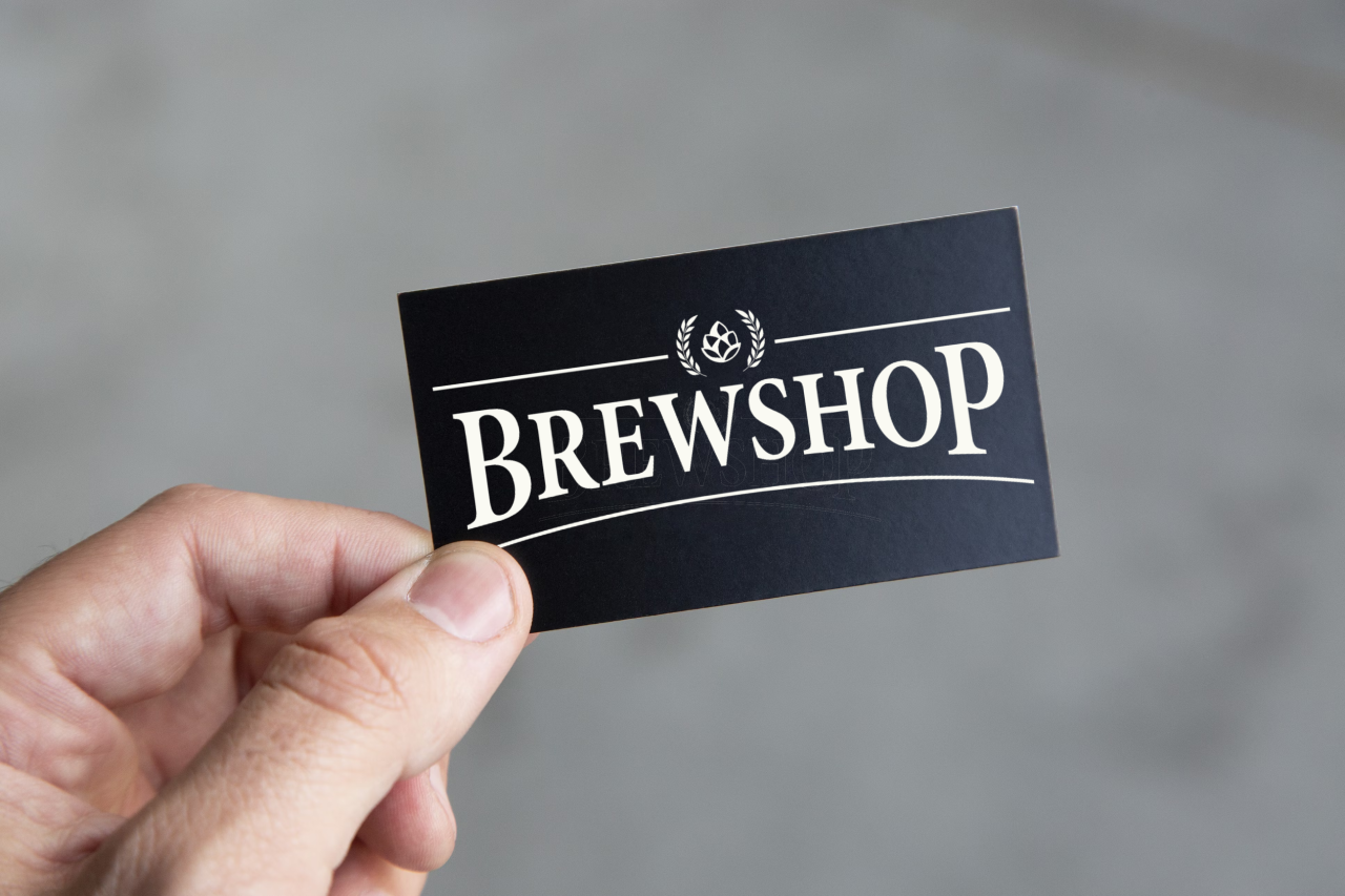En hånd holder et svart Brewshop Gavekort, med merkenavnet i fete, hvite bokstaver og en liten humlegrafikk over, som antyder eksklusive nettbutikk-tilbud.