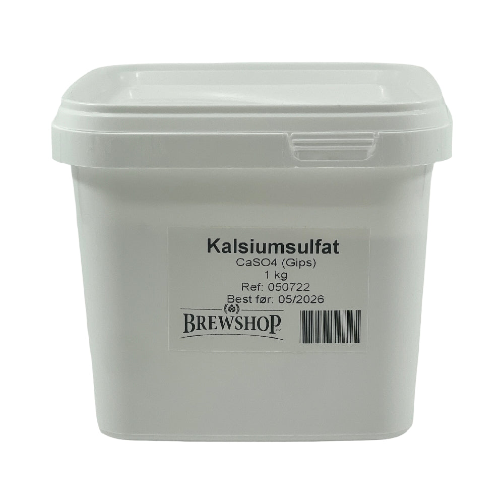 En hvit plastbeholder merket Kalsiumsulfat (gips) 1kg fra Brewshop, næringsmiddelgodkjent, med strekkode og best før 05/2026.