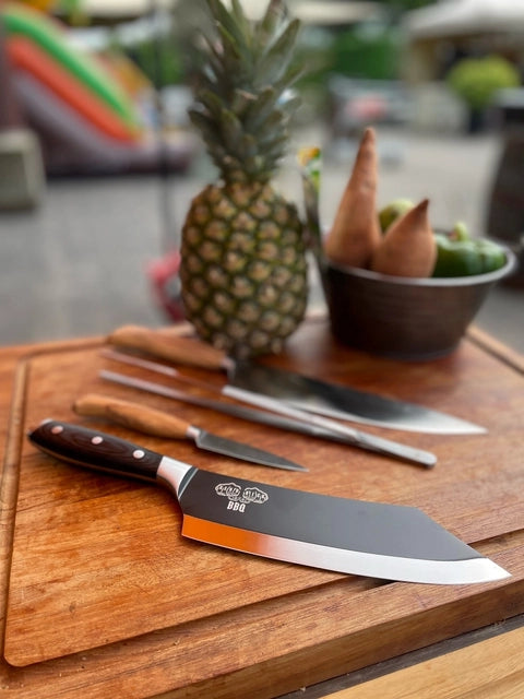 En Messermeister Bennie Kendrick BBQ-kniv og en ananas ligger på bordet, klar for presis oppskjæring med tysk X50 rustfritt stål.