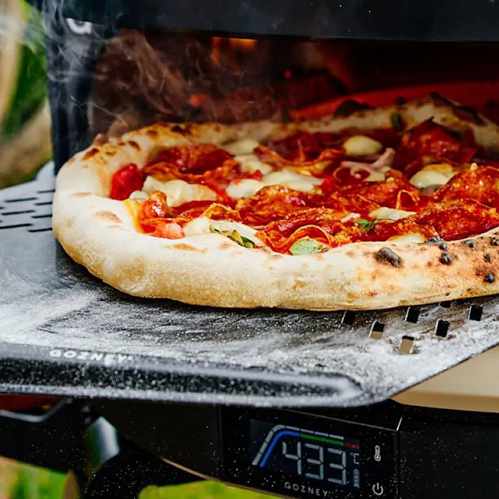 En pepperonipizza stekes ved 433°F, og dampen stiger opp mens kokken enkelt skyver den inn og ut av ovnen med Gozney Pro Pizzaspade 14" Large.