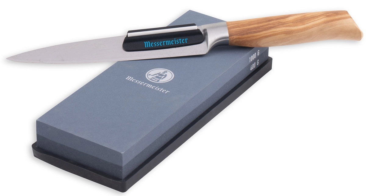 En kjøkkenkniv med trehåndtak hviler på toppen av den rektangulære slipesteinen Messermeister Slipestein 400 & 1000 Grit.