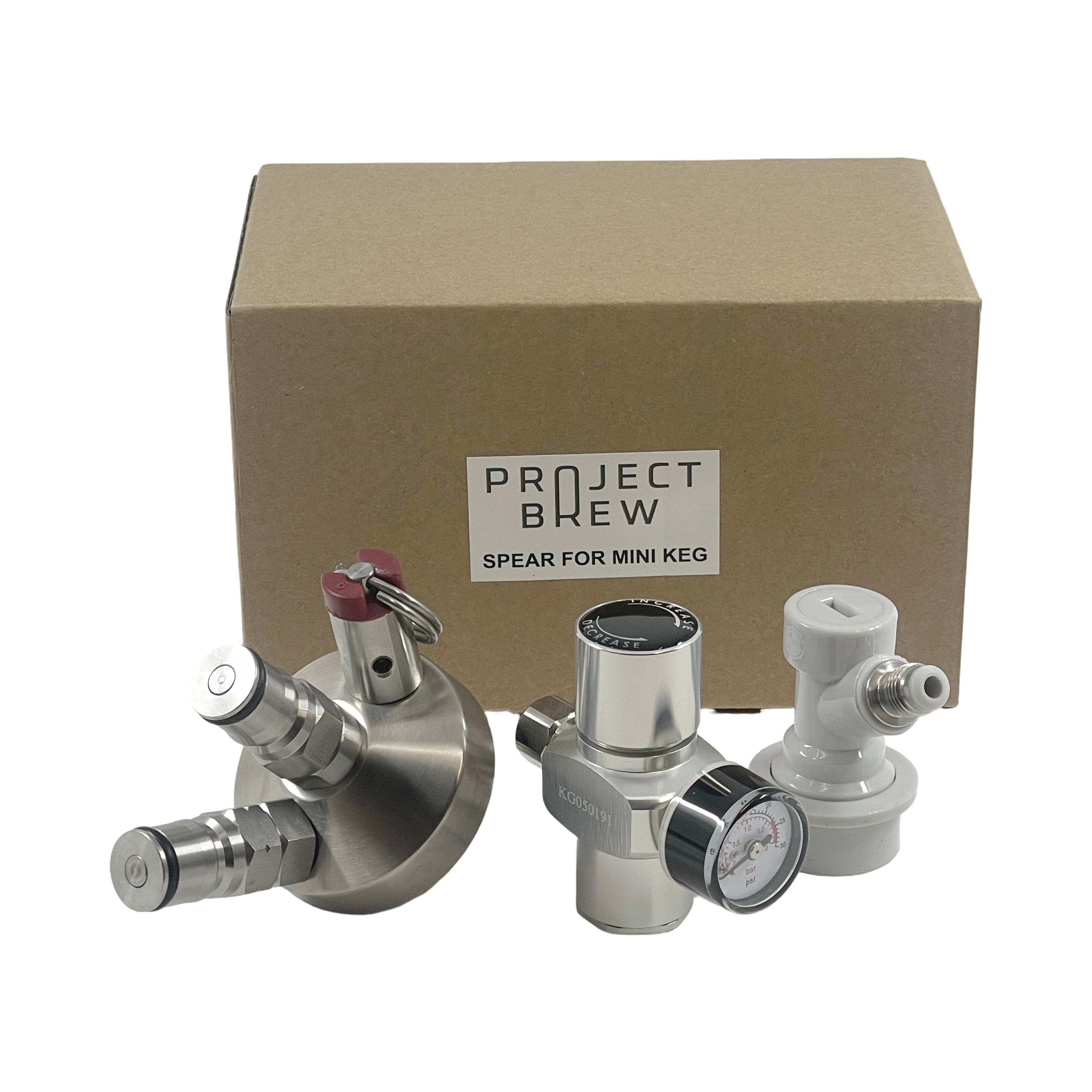 En gruppe metallgjenstander fra Project Brew Tilbehørsett til Project Brew 5L Mini Keg er plassert ved siden av esken.