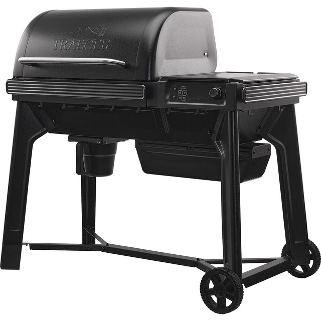 Traeger Woodridge Pelletsgrill i svart har WiFIRE-teknologi, lukket lokk, kontrollpanel, skorstein, to solide ben og to hjul for mobilitet, vist mot en hvit bakgrunn.